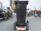 a black trash can sitting on a cart in a garage