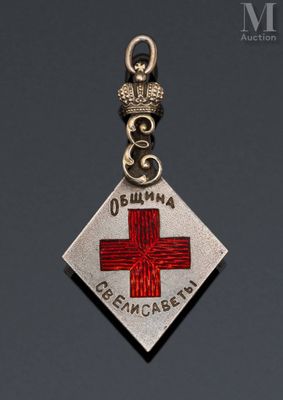 a close up of a silver and red cross charm on a black background