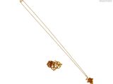 Collier et boucles d'oreilles plaqués or, avec un motif floral sur fond blanc