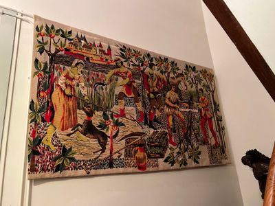 une photo d'une tapisserie accrochée au mur au-dessus de l'escalier