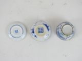 three small blue and white vases sitting on top of a white table