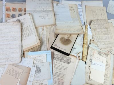a pile of old papers and a pair of scissors on a table