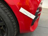 a red car with a sticker on the front of it