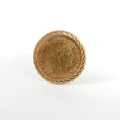 gros plan d'une pièce d'or sur une surface blanche