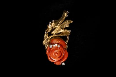 une image représentant une broche en forme de rose rouge sur fond noir