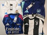 several soccer shirts are laid out on a white surface