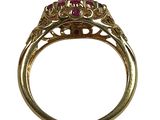 a close up of a gold ring with a ruby stone