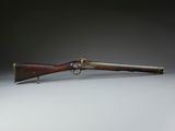 a rifle with a wooden barrel and brass fittings