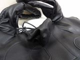 someone is wearing a pair of black leather gloves on a white surface