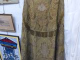 une robe sur un cintre dans une pièce où sont accrochés des tableaux au mur