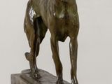 statue of a dog standing on a marble base on a table