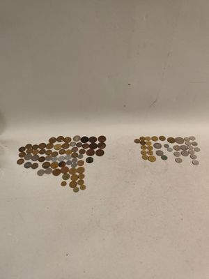 un évier blanc sur lequel sont posées de nombreuses pièces de monnaie