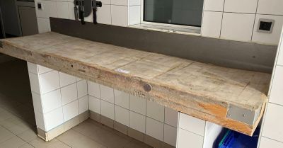 un comptoir en bois dans des toilettes publiques, avec une poubelle bleue