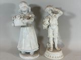 two figurines that are standing next to each other