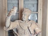 une statue représentant un homme tenant une coupe dans une pièce