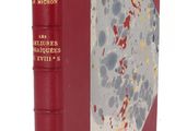 un vieux livre à la couverture rouge posé sur une table blanche