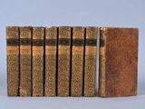 six books are lined up in a row on a gray surface