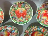 four colorful plates with designs on them on a white surface