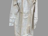 a white shirt hanging on a wooden hanger on a gray wall