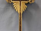 une croix en or richement décorée, surmontée d'un soleil rayonnant