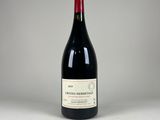 une bouteille de vin rouge posée sur une table blanche