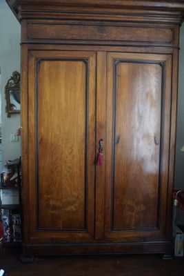 une grande armoire en bois dans le coin d'une pièce