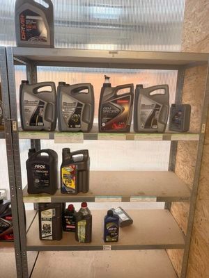 de nombreuses bouteilles d'huile moteur sur une étagère dans un garage