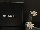 une boîte noire sur laquelle sont posées une paire de boucles d'oreilles