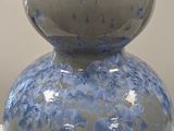 a blue and white vase sitting on a white table