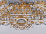 a lot of gold and silver glassware on a white table