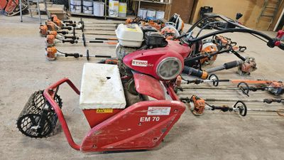 une photo d'une tondeuse à gazon rouge dans un garage
