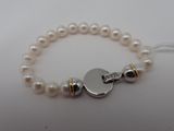 un gros plan sur un bracelet de perles blanches muni d'un fermoir en argent