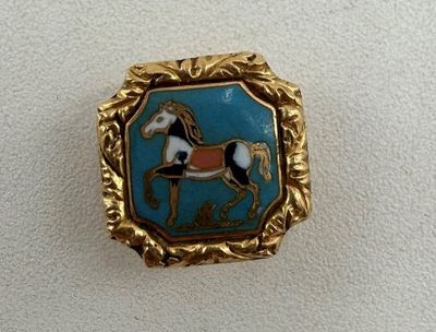 une photo d'un pin's sur lequel figure un cheval