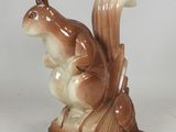a figurine of a squirrel that is sitting on a table