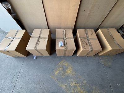 several cardboard boxes are stacked on the floor in front of a wall