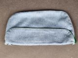 un gros plan d'un petit sac gris posé sur une surface marron
