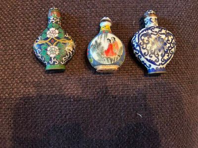 trois petites bouteilles posées sur une surface marron