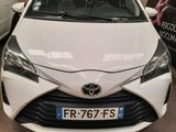 the front of a white toyota yaris parked in a garage