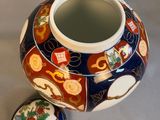 a small vase with a lid sitting on a table
