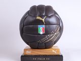 ballon de football en cuir noir posé sur un socle en bois et orné du logo Puma