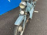 a blue motorcycle that is parked in front of a bus