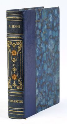 un vieux livre à la couverture bleue posé sur une surface blanche