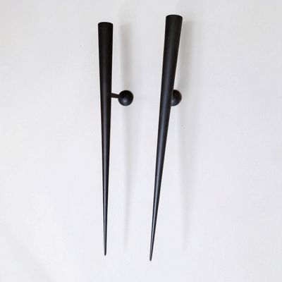 une paire de bougies en métal noir sur fond blanc