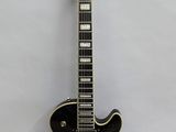 a close up of a black guitar on a white background