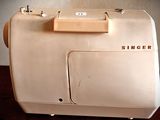 a white sewing machine sitting on a wooden table