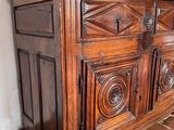 a wooden cabinet with a vase on top of it