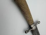 a close up of a knife on a table with a white background