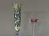 two glass vases sitting next to each other on a table