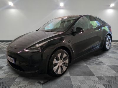 La Tesla Model Y est garée sur un sol en carrelage à damier.