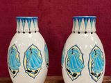 two vases sitting on a wooden table with a red background